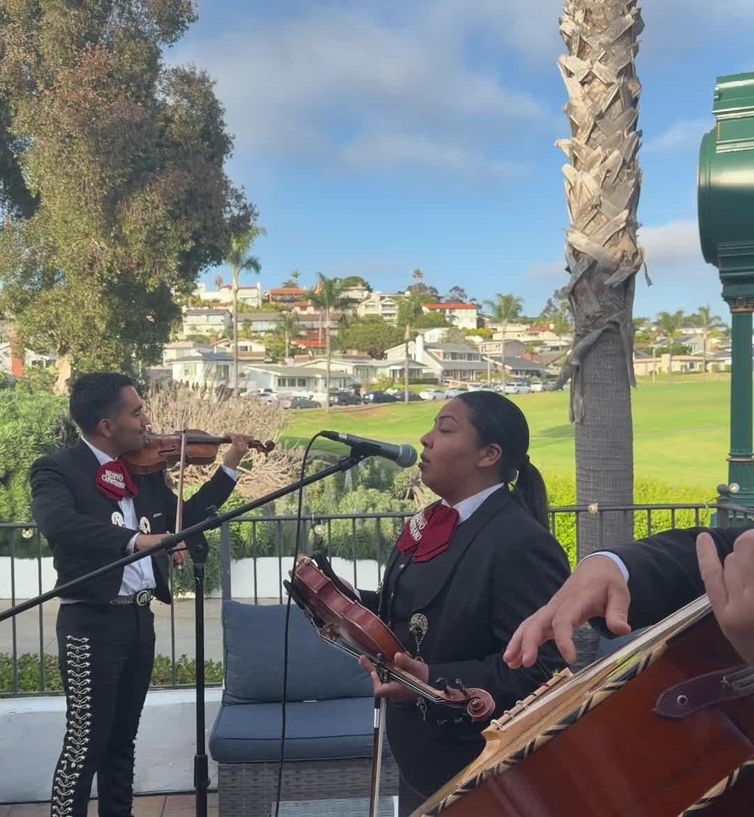 Mariachi Nuevo Capistrano performing live outdoors at an Orange County event, with violin, vocals and guitarrón